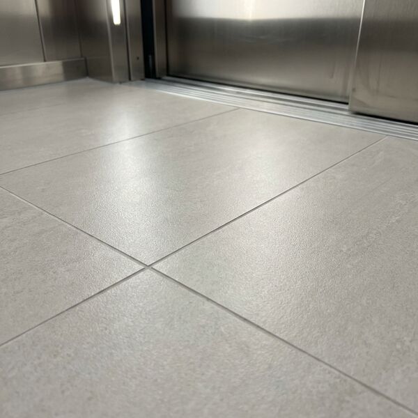Contemporary theme — grey vinyl floor detail with stainless skirting
