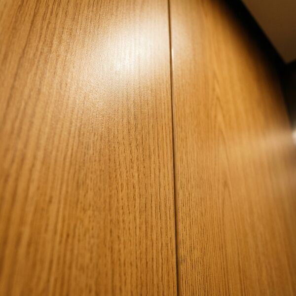 Warm heritage theme — wall detail showing oak veneer panel and brass reveal